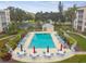 Aerial view of community pool showcasing ample lounge seating, tables, umbrellas and well maintained landscaping at 3950 Ironwood Cir # 206, Bradenton, FL 34209