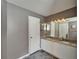 Bathroom featuring dual sinks with granite countertop, white cabinets, and a large mirror at 4033 Dover E Dr, Bradenton, FL 34203