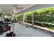 Covered patio with ceiling fans, screened windows, and serene backyard views at 4033 Dover E Dr, Bradenton, FL 34203