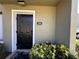 Welcoming front entrance with a black door, unit number, and landscaping at 4923 25Th W St # 104, Bradenton, FL 34207