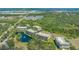 Aerial view of multi-story condominiums surrounded by lush trees and a pond with a fountain at 5242 Manorwood Dr Dr # 3A, Sarasota, FL 34235