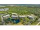 An aerial view shows the apartment complex with a pond and fountain as well as lots of trees at 5242 Manorwood Dr Dr # 3A, Sarasota, FL 34235