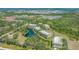 Aerial view of condo buildings nestled within lush green trees and a central pond with fountain at 5242 Manorwood Dr Dr # 3A, Sarasota, FL 34235