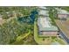 Overhead angle displays a well-maintained condo building next to a pond, surrounded by mature trees and lush landscaping at 5242 Manorwood Dr Dr # 3A, Sarasota, FL 34235