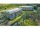 Beautiful aerial view of condo buildings with lush landscaping and a pond at 5242 Manorwood Dr Dr # 3A, Sarasota, FL 34235