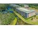 Aerial view shows building with screened lanais overlooking the waterway with lush landscaping providing serene privacy at 5242 Manorwood Dr Dr # 3A, Sarasota, FL 34235