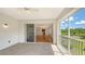 Balcony featuring tile flooring, screen, ceiling fan, and views of the interior living space and lush scenery at 5242 Manorwood Dr Dr # 3A, Sarasota, FL 34235