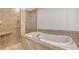This bathroom features tiled walls, a walk-in shower, and a soaking tub with chrome hardware at 5242 Manorwood Dr Dr # 3A, Sarasota, FL 34235