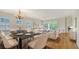Bright dining room featuring a stylish chandelier, marble table, and natural light with balcony view at 5242 Manorwood Dr Dr # 3A, Sarasota, FL 34235