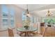 Dining area with glass table, seating four, with views into the living room at 5242 Manorwood Dr Dr # 3A, Sarasota, FL 34235