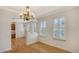 Bright dining room featuring elegant chandelier, white plantation shutters, and hardwood floors at 5242 Manorwood Dr Dr # 3A, Sarasota, FL 34235