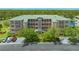 Exterior showcases an attractive condo building boasting multiple stories, balconies, lush landscaping, and ample parking at 5242 Manorwood Dr Dr # 3A, Sarasota, FL 34235