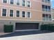 Exterior shot of the condo building showing the private covered parking garage with manicured landscaping at 5242 Manorwood Dr Dr # 3A, Sarasota, FL 34235