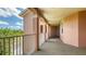 Exterior hallway featuring tile floors, large columns, and a view of blue skies and green trees, offering a light-filled, open space at 5242 Manorwood Dr Dr # 3A, Sarasota, FL 34235