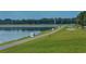 A wide shot shows the lake with markers and a walking path next to it, with trees in the distance at 5242 Manorwood Dr Dr # 3A, Sarasota, FL 34235