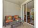 Cozy balcony features wicker seating, a glass table, and a sliding glass door to the interior at 5601 Bentgrass Dr # 10-105, Sarasota, FL 34235