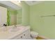 Clean, well-lit bathroom with a white vanity, sink, toilet, and shower at 5601 Bentgrass Dr # 10-105, Sarasota, FL 34235