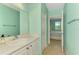Light-blue bathroom with white cabinets and modern fixtures at 5601 Bentgrass Dr # 10-105, Sarasota, FL 34235