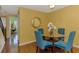 Cozy dining area with a glass table, seating for four, and an elegant decorative mirror on the mustard colored wall at 5601 Bentgrass Dr # 10-105, Sarasota, FL 34235