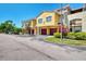 Sunny two-story townhomes with garages, landscaping, and a shared parking area at 5601 Bentgrass Dr # 10-105, Sarasota, FL 34235