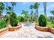 Elegant fountain feature surrounded by brick pathways, lush greenery and palm trees at 5601 Bentgrass Dr # 10-105, Sarasota, FL 34235