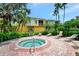 Inviting hot tub with lounge chairs and tropical landscaping, set in a community of colorful townhomes at 5601 Bentgrass Dr # 10-105, Sarasota, FL 34235