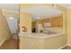 Open kitchen with light wood cabinetry, white appliances, and eat-in bar area with access to the living area at 5601 Bentgrass Dr # 10-105, Sarasota, FL 34235