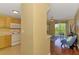 Bright living area with kitchen view, hardwood floors, and sliding doors to the balcony at 5601 Bentgrass Dr # 10-105, Sarasota, FL 34235