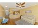 Cozy living room with open view to kitchen, features wood floors, ceiling fan, and a comfortable white couch at 5601 Bentgrass Dr # 10-105, Sarasota, FL 34235