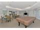 Comfortable lounge area with a pool table, tables with chairs, and a bar, ideal for socializing at 5601 Bentgrass Dr # 10-105, Sarasota, FL 34235