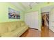 Well-lit office space with a stylish sofa, closet, and a colorful painting at 5601 Bentgrass Dr # 10-105, Sarasota, FL 34235
