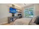 Modern bedroom with custom built-in desk, shelving, and storage for shoes underneath a large screen TV at 5793 Long Shore Loop, Sarasota, FL 34238