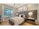 Cozy bedroom featuring a padded headboard and natural light from the window at 5793 Long Shore Loop, Sarasota, FL 34238
