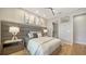 Well-lit bedroom features an upholstered headboard, bedside tables with lamps, and a view of the ensuite bathroom at 5793 Long Shore Loop, Sarasota, FL 34238
