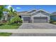 Charming home featuring a three-car garage, paver driveway, lush landscaping and well manicured lawn at 5793 Long Shore Loop, Sarasota, FL 34238