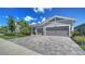 Beautiful home features a three-car garage, paver driveway and lush landscaping at 5793 Long Shore Loop, Sarasota, FL 34238