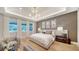 Bright main bedroom suite with modern lighting, wall decor, and a comfortable seating area at 5793 Long Shore Loop, Sarasota, FL 34238