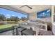 Outdoor kitchen with stainless steel appliances, granite countertops, bar seating and pond view at 5793 Long Shore Loop, Sarasota, FL 34238