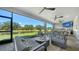 Screened-in patio with stylish seating, outdoor kitchen, and a beautiful view of the pond at 5793 Long Shore Loop, Sarasota, FL 34238