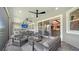 Covered patio with comfortable seating, ceiling fans, outdoor kitchen, and a view of the backyard and pond at 5793 Long Shore Loop, Sarasota, FL 34238