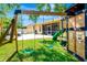 Spacious backyard showcasing a playhouse, swing set, and outdoor patio area at 6729 45Th E Ter, Bradenton, FL 34203