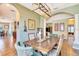 Dining room with a long wooden table, upholstered chairs, stylish lighting, and arched doorway at 6729 45Th E Ter, Bradenton, FL 34203