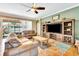 Bright living room featuring comfortable sofas, a large entertainment center, and a view to the backyard at 6729 45Th E Ter, Bradenton, FL 34203