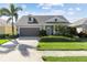 Charming single-story home featuring a well-manicured lawn, a two-car garage, and mature palm trees at 6936 White Willow Ct, Sarasota, FL 34243
