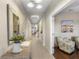 Bright hallway featuring tile flooring, decorative mirror, and stylish accents leading into the home's interior at 6936 White Willow Ct, Sarasota, FL 34243