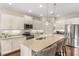 Bright kitchen with stainless appliances, white cabinetry, granite counters, and spacious island at 6936 White Willow Ct, Sarasota, FL 34243