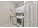 Laundry room with a modern washer and dryer, overhead cabinets and extra storage space at 6936 White Willow Ct, Sarasota, FL 34243