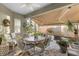 Enclosed patio featuring a ceiling fan and roll down sunshades, complete with dining table and furniture at 6936 White Willow Ct, Sarasota, FL 34243