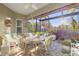 Covered patio with dining set, ceiling fan, and views of the landscaped backyard at 6936 White Willow Ct, Sarasota, FL 34243