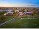 Scenic aerial view of houses backing onto golf course and a large lake in a peaceful neighborhood at 72 Grande Fairway, Englewood, FL 34223